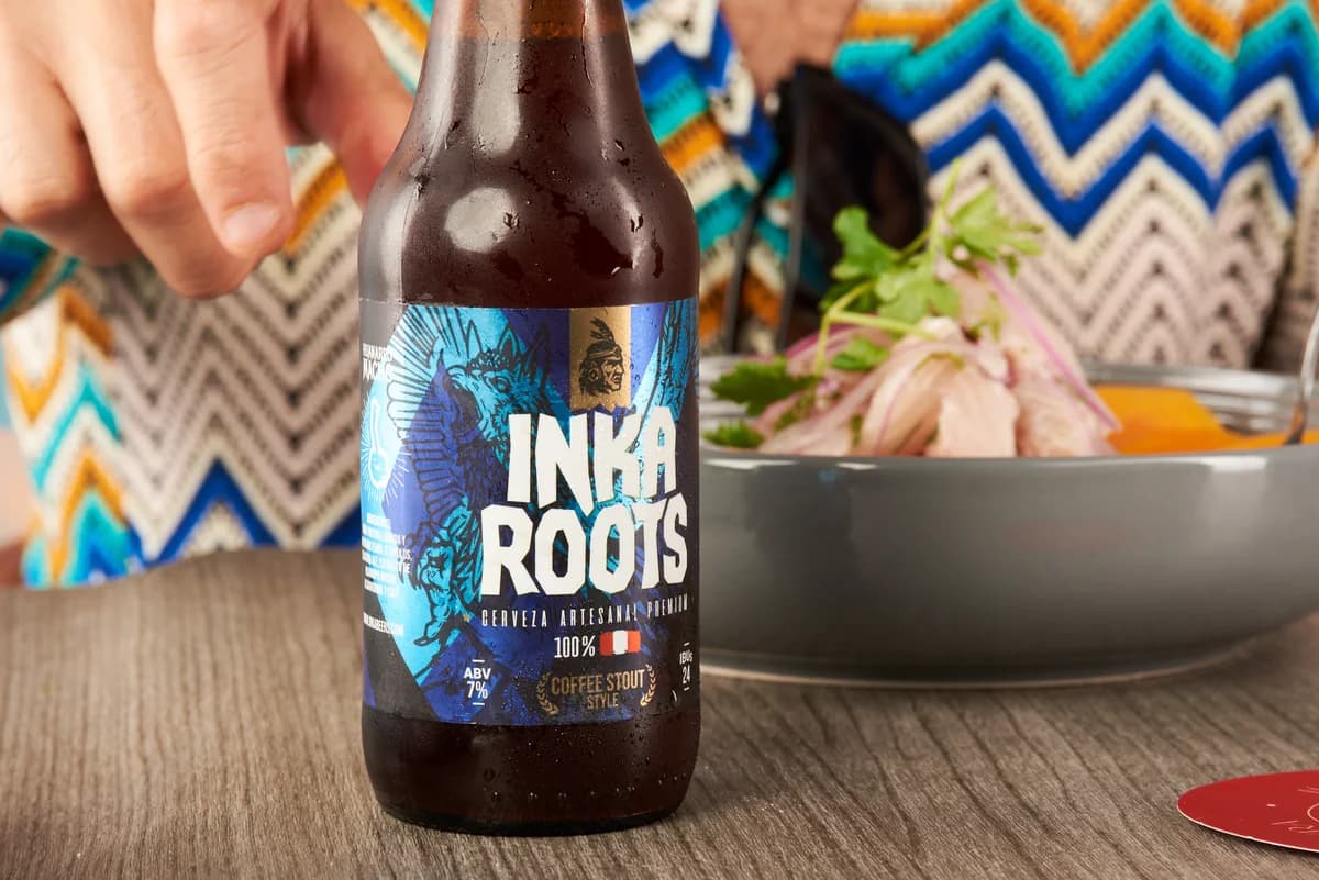 Plato de cocina contemporánea peruana acompañado con red ale Inkaroots.
